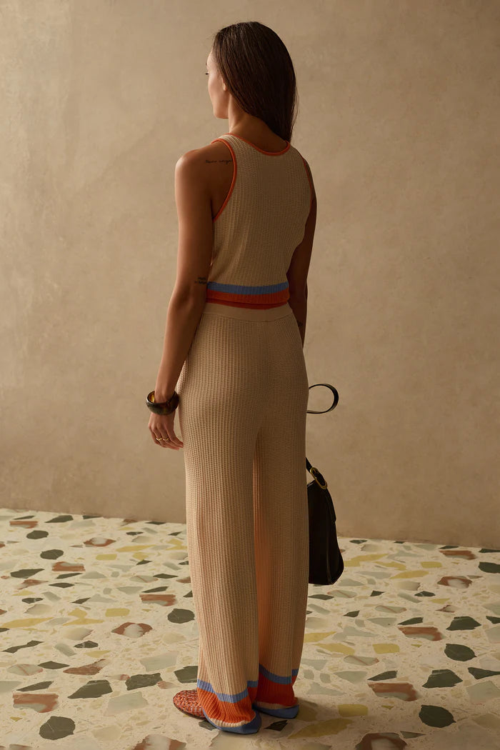knit wide leg cream pants with orange and blue stripe on bottom