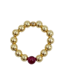 gold beaded ring with garnet stone in the middle
