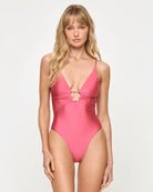 pink one piece swimsuit with gold hardware in the center