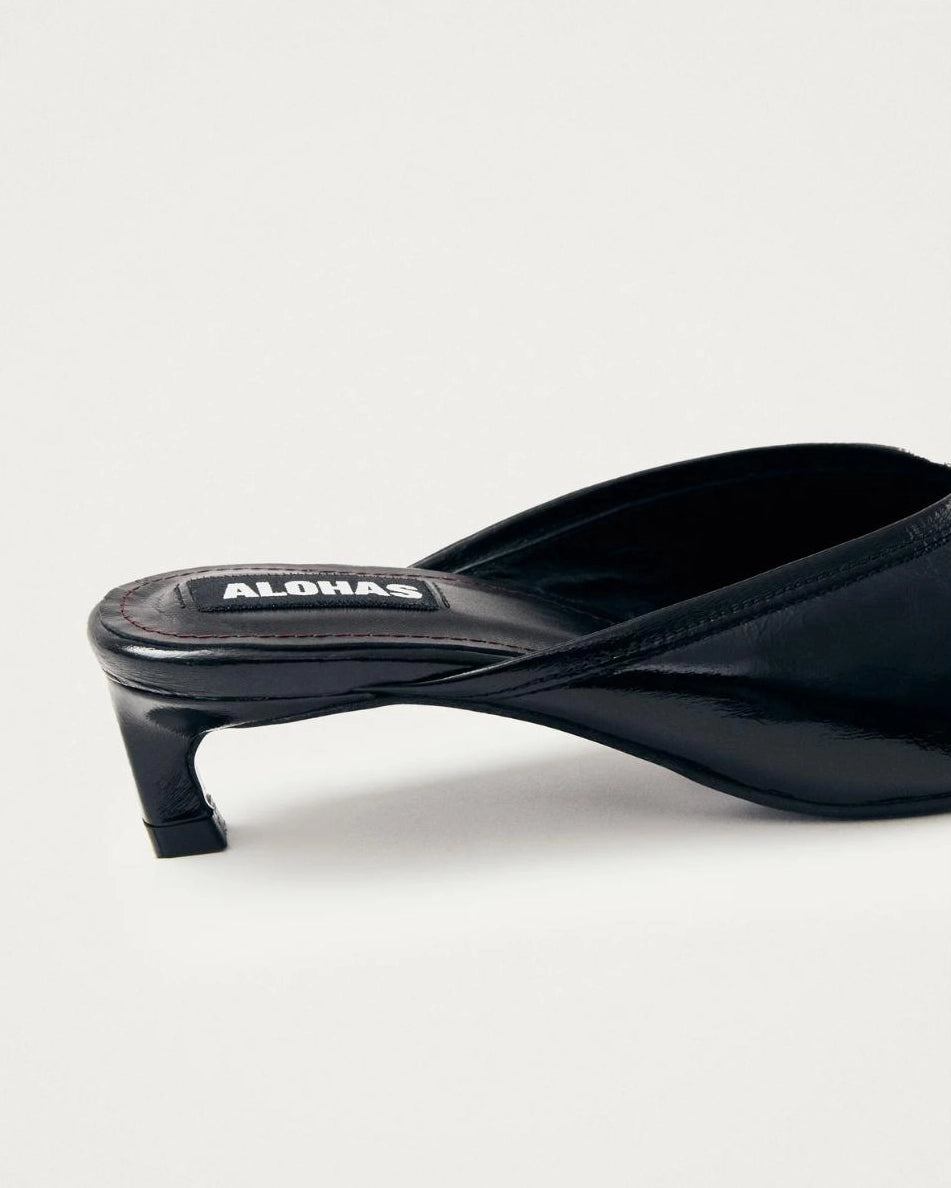 black leather mules with a pointed toe with 'Alohas' logo on them
