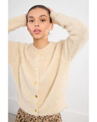 cream colored cardigan with gold buttons