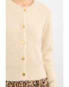 cream colored cardigan with gold buttons