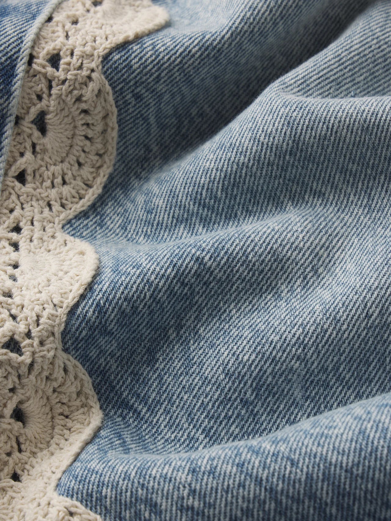 cropped light wash denim pant with a cream crochet detail on the sides 