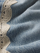 cropped light wash denim pant with a cream crochet detail on the sides 