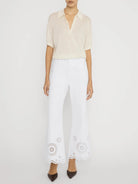 wide leg white denim pant with eyelet detail at the bottom