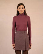 Woman wearing a rust coloured turtleneck sweater