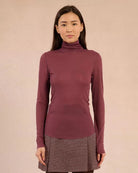 Woman wearing a rust coloured turtleneck sweater