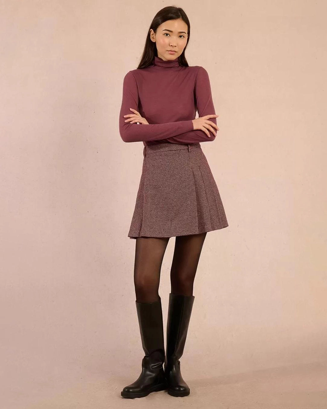 Woman wearing a rust coloured turtleneck sweater