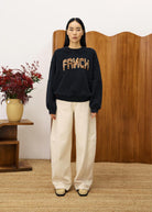 Person wearing a black sweater with FRNCH text