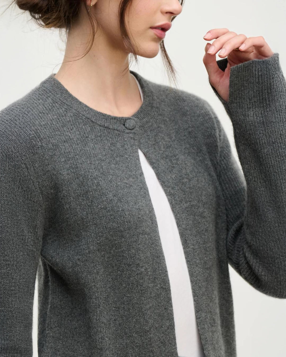 a woman wears a cashmere cardigan sweater in grey with a single button at the collar