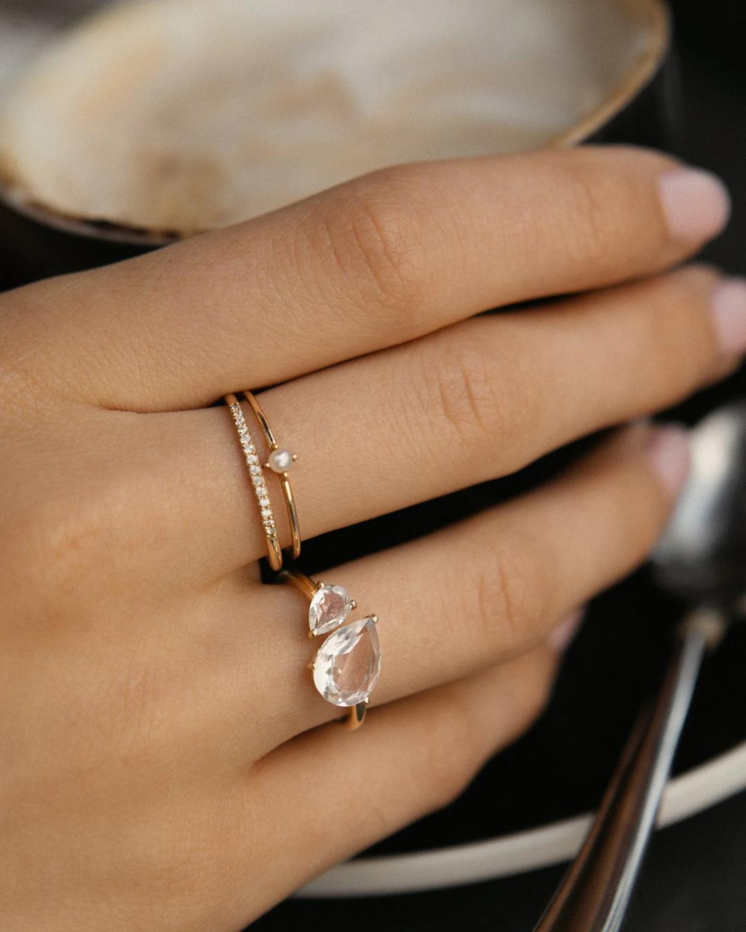 gold ring with a large diamond on one side and a little one beside it