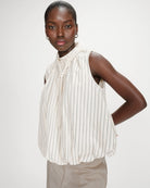 sleeveless top with bubble bottom and a tie at the neck in cream