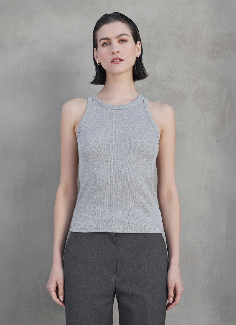A woman wearing a grey ribbed tank top and grey trousers