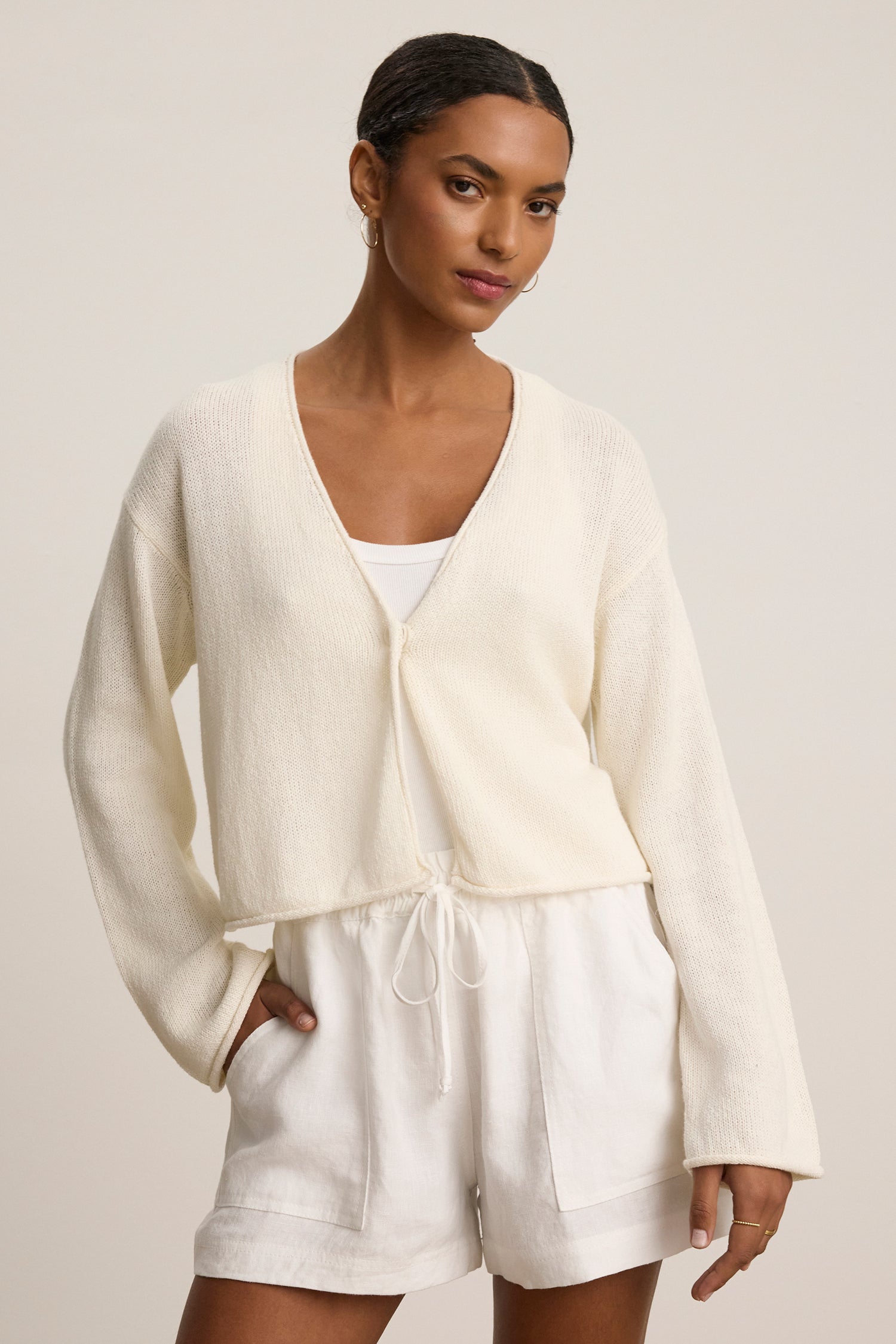 a cream cashmere sweater with a button in the middle