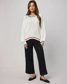 white sweater with navy at the collar and red at the bottom
