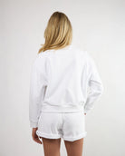 woman wearing a white crew neck sweatshirt and matching shorts
