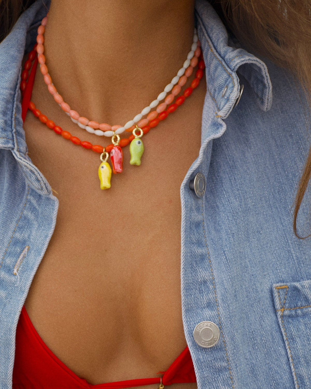 white beaded necklace with a red fish pendant
