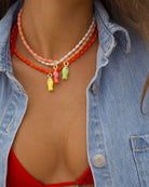 white beaded necklace with a red fish pendant