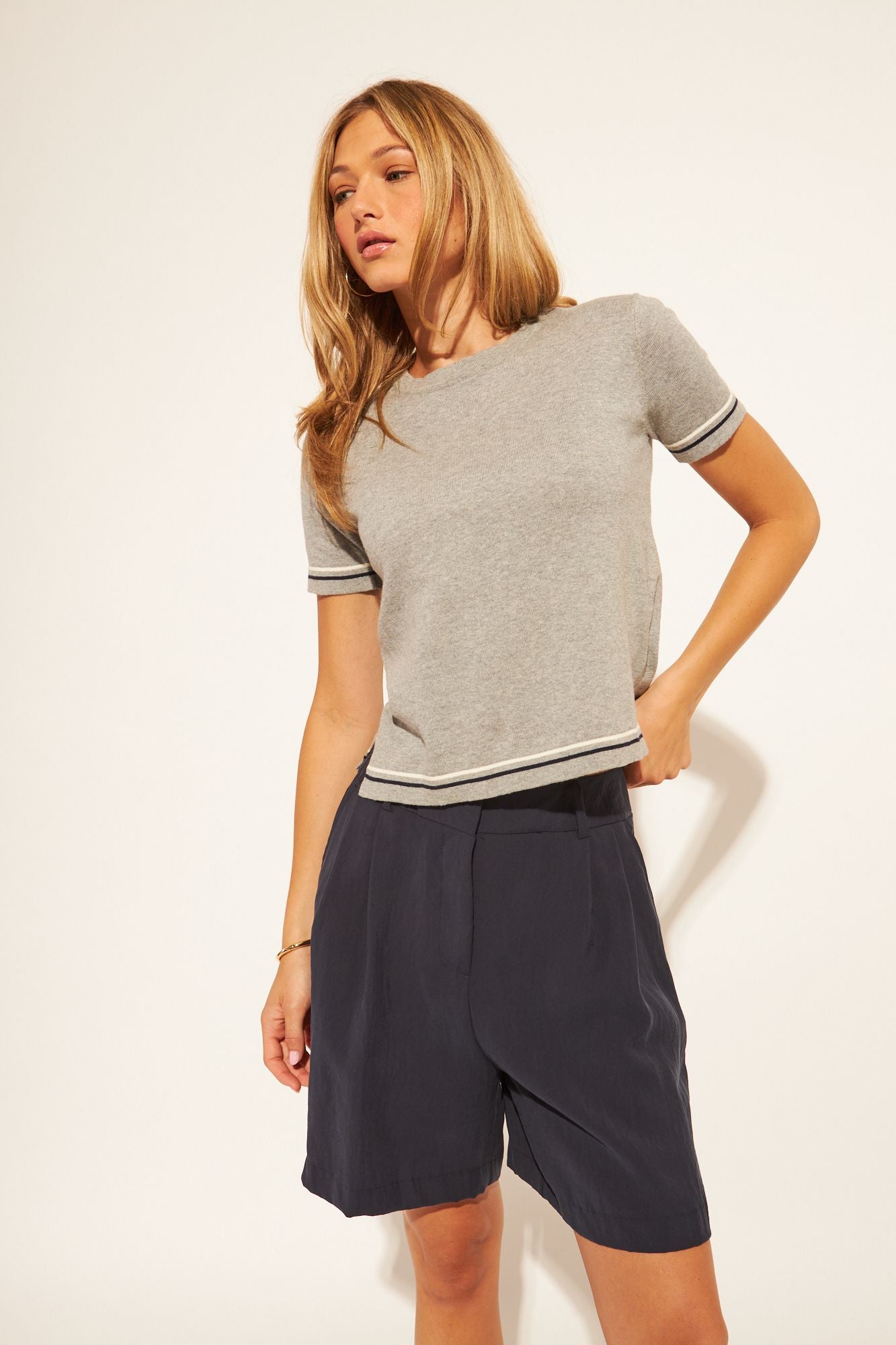 grey t-shirt with a black and white stripe on sleeves and bottom