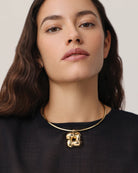 statement gold necklace with a woven pendant 