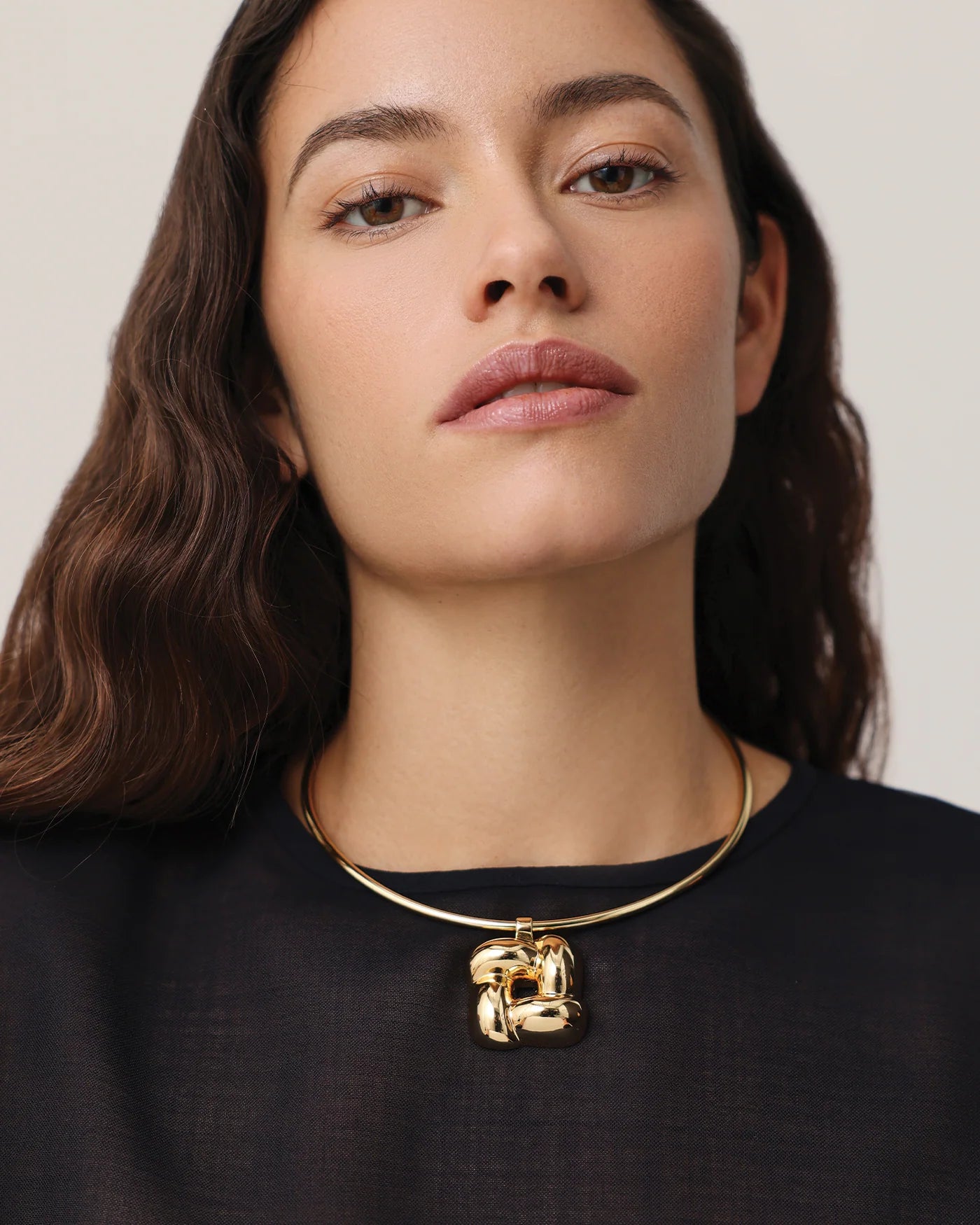 statement gold necklace with a woven pendant 