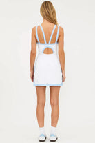 Woman wearing a white tennis dress with blue trim